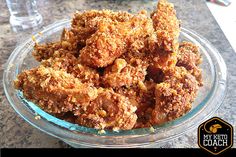 a glass bowl filled with fried food on top of a table