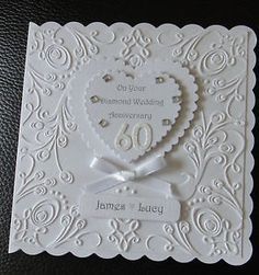 a white wedding card with a heart on it