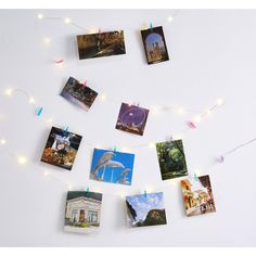 many pictures are hung on the wall with string lights