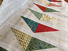 a close up of a quilted table runner with different colored triangles on the side