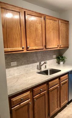 an empty kitchen with wooden cabinets and stainless steel dishwasher on the counter top