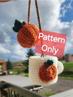 two crocheted pumpkins hanging from strings with a sign that says pattern only