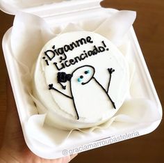 a white cake with black writing on it in a foam container that says digumme liceciada