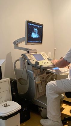 a man sitting in front of a computer monitor on top of a desk with an x - ray