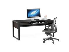 an office desk with a computer on it and a black chair next to the desk