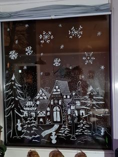 a window decorated with snowflakes and houses