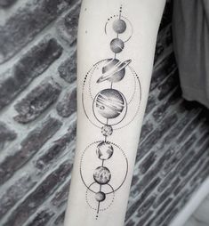 a black and white tattoo with planets on the arm