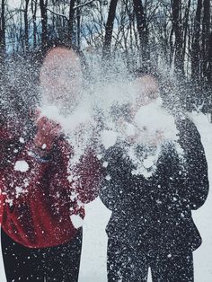 three people are throwing snow in the air