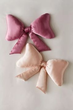 three satin bows are shown on a white surface with one pink and the other light pink