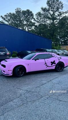 a pink car parked in front of a blue building