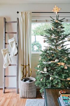 a decorated christmas tree in front of a window