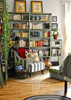 a living room filled with lots of furniture and bookshelves full of books on top of them