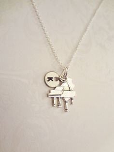 "Beautiful Antique Silver Plated Piano Necklace- Simplistically Elegant, Artsy and Unique. Such a great statement on many levels. Great gift for anyone who loves unique necklaces! Looks really amazing, Classy and Awesome all rolled into one! Includes: -Initial circle of choice -Comes on a Stainless Steel Necklace -Piano pendant is Antique Silver Plated Metal and Very Elegant 21.0mm x 16.0mm in size About the size of a Quarter- Super Cute! -Comes in a beautiful jewelry gift box FUN FACTS: Pianos Gifts For Musicians, Antique Piano, Piano Gifts, Music Teacher Gift, Music Teacher Gifts, Piano Teacher, Grand Piano, Music Teacher, Stainless Steel Necklace