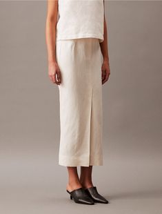 A modern midi skirt with a tailored look in a soft linen blend. Finished with tonal stitching for a clean look and a vented front for easy movement.  Material: 40% Cupro, 35% Linen, 25% Cotton. Linen Blend, Calvin Klein, Midi Skirt