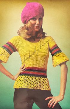 a woman wearing a yellow sweater and pink hat