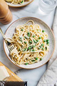 a plate of pasta with peas and parmesan cheese