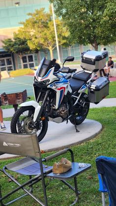 two motorcycles parked next to each other on top of a cement slab in the grass