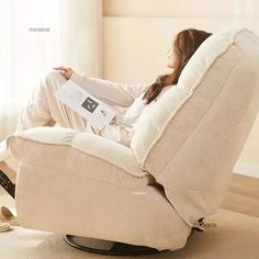 a woman sitting in a recliner chair with her feet up on the back of it