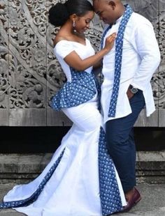 a man and woman dressed in blue and white posing for the camera with their arms around each other