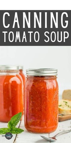 two jars filled with tomato sauce and bread on top of a white table next to each other