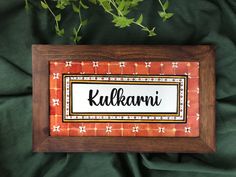 a wooden frame with the name kullkawi on it and flowers in front