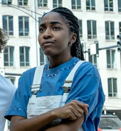 two women standing next to each other in front of a building