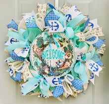 a blue and white wreath with an anchor, seagulls and words on it