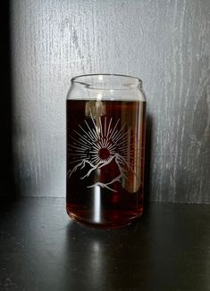 a glass with a design on it sitting on a table