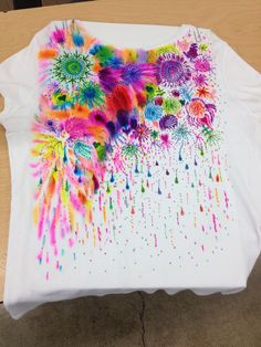 a white t - shirt with colorful sprinkles on it