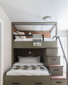 a bunk bed with drawers underneath it and stairs leading up to the top floor in a bedroom