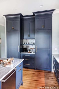 a kitchen with wooden floors and blue cabinets