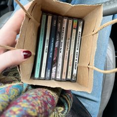 a person holding a box full of dvds