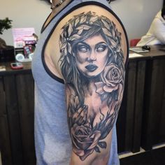 a woman's arm with roses and leaves on it