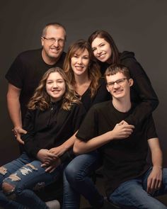 a family posing for a photo in front of a black background with the caption's name on it