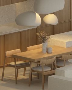 a wooden table surrounded by white chairs and lights in a room with wood paneling