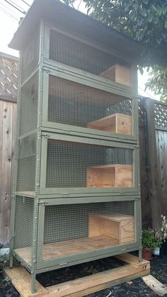 a large green bird cage sitting on top of a wooden platform