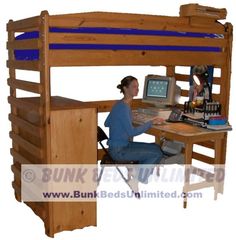 a person sitting at a desk in front of a computer on top of a bunk bed