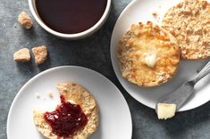 two plates with biscuits and jam on them next to a cup of coffee, butter