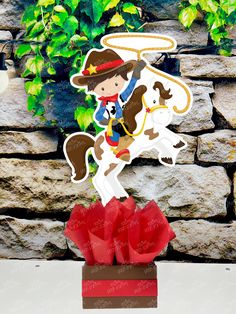 a paper cutout of a cowboy riding a horse on top of a red box