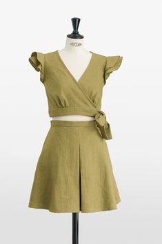 Elevate your style with our Green Ruffle Top and Pleated Skirt Set, a masterpiece in sustainable fashion. This two-piece set exudes innate elegance, from the playful ruffle top to the meticulously pleated skirt that adds sophisticated texture to both the front and back. Crafted with exceptional dedication, the high-quality linen selected promises not just a soft touch but durability that honors traditional craftsmanship. 🍃 With an elegant tie closure, the top offers a customizable fit and a tou Summer Sets With Ruffled Skirt, Spring Fitted Set With Ruffled Skirt, Fitted Spring Set With Ruffled Skirt, Chic Summer Skirt Set With Short Sleeves, Summer Ruffled Fitted Skirt Set, Fitted Ruffled Skirt Set For Summer, Fitted Ruffle Skirt Set For Summer, Spring Mini Length Two-piece Dress Set, Spring Two-piece Mini Dress