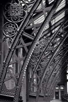 black and white photograph of the inside of an old train station with iron railings