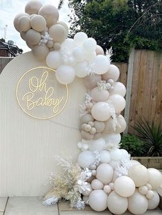 an arch made out of balloons with the words hello baby on it and snowflakes