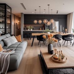 a living room filled with furniture next to a dining room table and chairs in front of a window