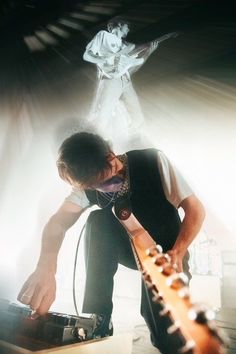 a man playing an electric guitar on stage