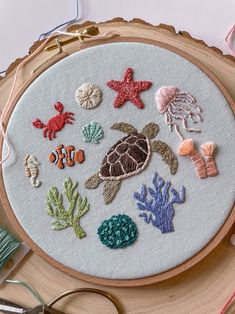 a close up of a embroidery on a piece of wood with scissors and other items