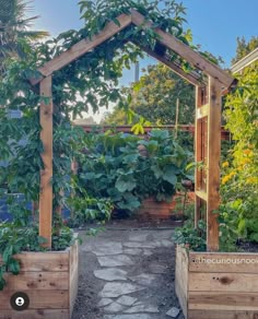 an outdoor garden with wooden planters and trelliss on the sides, surrounded by greenery