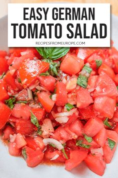 a white plate topped with sliced tomatoes and basil