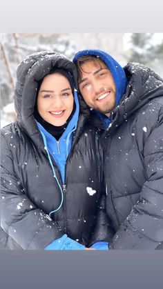 a man and woman are posing for a photo in the snow with their arms around each other