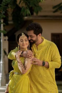 a man and woman dressed in yellow posing for the camera with their arms around each other