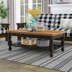 a living room with black and white plaid couches, coffee table and rugs